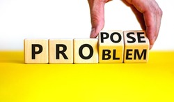 Solving a problem and propose symbol. Businessman turns wooden cubes, changes the word 'problem' to 'propose'. Beautiful white background. Business, problem and propose concept. Copy space.