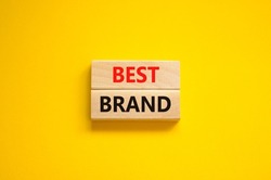 Best brand symbol. Concept words Best brand on wooden blocks on a beautiful yellow background. Business and best brand concept. Copy space.