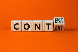 Content and context symbol. Turned a wooden cube and changed the word context to content. Beautiful orange table, orange background. Business and content and context concept. Copy space.