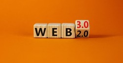 WEB 2 or 3 symbol. Turned a wooden cube and changed words WEB 2.0 to WEB 3.0. Beautiful orange table, orange background, copy space. Business, technology and WEB 2.0 or 3.0 concept.