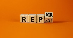 Repeat and repair symbol. Turned a wooden cube and changed the word repeat to repair. Beautiful orange table, orange background, copy space. Business, repeat and repair concept.