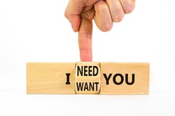 I need and want you symbol. Psychologist turns wooden cubes and changes words I want you to I need you. Beautiful white table white background, copy space. Psychological, i need and want you concept.