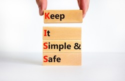 KISS keep it simple and safe symbol. Concept words KISS keep it simple and safe wooden blocks. Beautiful white table, white background. Business and KISS keep it simple and safe concept. Copy space.