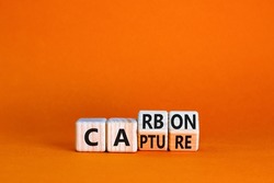Carbon capture symbol. Turned wooden cubes and changed the concept word Carbon to Capture. Beautiful orange table orange background. Business ecological carbon capture concept. Copy space.