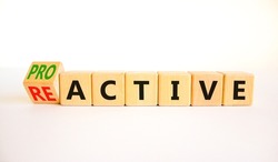 Reactive or proactive symbol. Turned wooden cubes and changed the concept word reactive to proactive. Beautiful white table white background, copy space.Business and reactive or proactive concept.