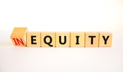 Inequity or equity symbol. Turned wooden cubes and changed the concept word Inequity to Equity. Beautiful white table white background. Business and inequity or equity concept. Copy space.