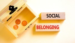 Social belonging symbol. Wooden blocks with concept words Social belonging on beautiful white background. Wooden chest with coins. Business political social belonging concept. Copy space.