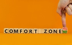 Yes or no comfort zone symbol. Businessman turns wooden cubes and changes words Comfort zone yes to Comfort zone no. Beautiful orange background, copy space. Business, psychology comfort concept.
