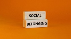 Social belonging symbol. Wooden blocks with concept words Social belonging on beautiful orange background. Business political social belonging concept. Copy space.
