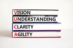 VUCA vision understanding clarity agility symbol. Concept words VUCA vision understanding clarity agility on books. White background. Business and VUCA vision understanding clarity agility concept.