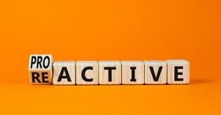 Reactive or proactive symbol. Turned wooden cubes and changed the concept word reactive to proactive. Beautiful orange table orange background, copy space.Business and reactive or proactive concept.