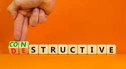 Destructive or constructive symbol. Businessman turns cubes changes the concept word Destructive to Constructive. Beautiful orange background. Business constructive destructive concept. Copy space.