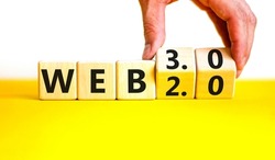 WEB 2.0 or 3.0 symbol. Businessman turns wooden cubes and changes concept words WEB 2.0 to WEB 3.0. Beautiful yellow table white background copy space. Business technology and WEB 2 or 3 concept.