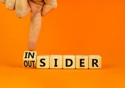 Insider or outsider symbol. Businessman turns wooden cubes and changes the concept word Insider to Outsider. Beautiful orange table orange background. Business insider or outsider concept. Copy space.