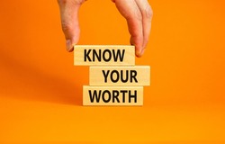 Know your worth symbol. Concept words Know your worth on wooden blocks. Businessman hand. Beautiful orange table orange background. Business and know your worth concept. Copy space.