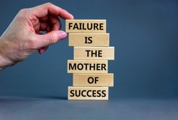 Failure or success symbol. Wooden blocks with words A failure is the mother of success. Beautiful grey table grey background. Businessman hand. Business, failure or success concept. Copy space.