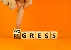Regress or progress symbol. Businessman turns wooden cubes and changes the word Regress to Progress. Beautiful orange table orange background. Business regress or progress concept. Copy space.