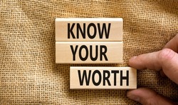 Know your worth symbol. Concept words Know your worth on wooden blocks. Businessman hand. Beautiful canvas table canvas background. Business and know your worth concept. Copy space.