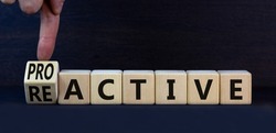 Reactive or proactive symbol. Turned wooden cubes and changed the concept word reactive to proactive. Beautiful grey table grey background, copy space.Business and reactive or proactive concept.