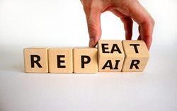 Repeat and repair symbol. Businessman turns wooden cubes and changes the word 'repeat' to 'repair'. Beautiful white background, copy space. Business, repeat and repair concept.