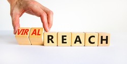 Viral reach symbol. Businessman turns wooden cubes and changes words 'reach' to 'viral reach'. Beautiful white table, white background, copy space. Business, viral reach concept.