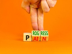 Pain or progress symbol. Concept words Pain or Progress on wooden cubes. Businessman hand. Beautiful orange table orange background. Business and pain or progress concept. Copy space.