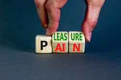 Pain or pleasure symbol. Concept words Pain or Pleasure on wooden cubes. Businessman hand. Beautiful grey table grey background. Business and pain or pleasure concept. Copy space.