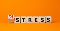 Distress or stress symbol. Turned the wooden cube and changed the concept word Distress to Stress. Beautiful orange table orange background, copy space. Psychlogical and stress or distress concept.