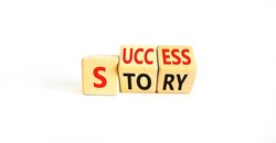 Success story symbol. Concept words Success story on wooden cubes. Beautiful white table white background. Business and Success story concept. Copy space.