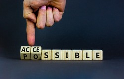 Possible and accessible symbol. Businessman turns wooden cubes and changes the word possible to accessible. Business and possible or accessible concept. Beautiful grey background, copy space.