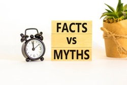 Facts vs myths symbol. Concept words Facts vs myths on wooden blocks on a beautiful white table white background. Black alarm clock. Business, finacial and facts vs myths concept. Copy space.