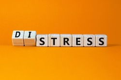 Stress or distress symbol. Turned wooden cubes and changed the concept word Stress to Distress. Beautiful orange table orange background, copy space. Psychlogical distress or stress concept.