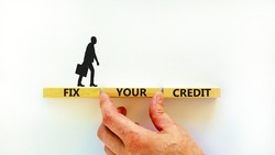Fix your credit symbol. Concept words Fix your credit on wooden blocks on a beautiful white table white background. Businessman hand. Business, finacial and fix your credit concept. Copy space.