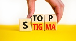 Stop stigma symbol. Concept words Stop stigma on wooden cubes. Businessman hand. Beautiful yellow table white background. Business and Stop stigma concept. Copy space.