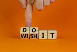 Wish and do it symbol. Businessman turns cubes and changes words 'wish it' to 'do it'. Beautiful orange table, orange background. Business and wish and do it concept. Copy space.