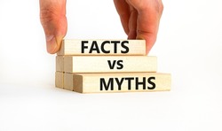 Facts vs myths symbol. Concept words Facts vs myths on wooden blocks on a beautiful white table white background. Businessman hand. Business, finacial and facts vs myths concept. Copy space.