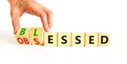 Blessed or obsessed symbol. Businessman turns wooden cubes and changes the concept word Obsessed to Blessed. Beautiful white table white background. Business blessed or obsessed concept. Copy space.