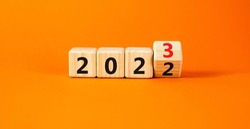 2023 happy new year symbol. Wooden cubes symbolize the change from 2022 to the new year 2023. Beautiful orange table orange background. Copy space. Business and 2023 happy new year concept.