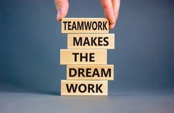 Teamwork makes dream work symbol. Concept words Teamwork makes the dream work on wooden blocks on a beautiful grey background. Businessman hand. Business Teamwork makes dream work concept. Copy space.