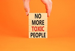 No more toxic people symbol. Concept words No more toxic people on wooden blocks on a beautiful orange table orange background. Psychologist hand. Business, psychological no more toxic people concept.