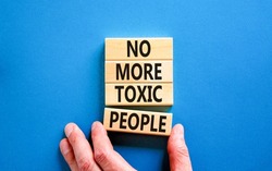 No more toxic people symbol. Concept words No more toxic people on wooden blocks on a beautiful blue table blue background. Psychologist hand. Business, psychological no more toxic people concept.