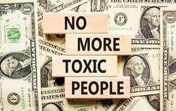 No more toxic people symbol. Concept words No more toxic people on wooden blocks on a beautiful background from dollar bills. Business, psychological no more toxic people concept.