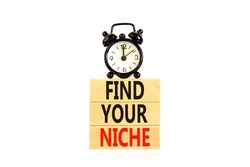 Find your niche symbol. Concept words Find your niche on wooden blocks. Black alarm clock. Beautiful white table white background. Business and find your niche concept. Copy space.
