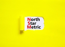 NSM north star metric symbol. Concept words NSM north star metric on white paper on a beautiful yellow background. Business and NSM north star metric concept. Copy space.