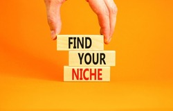 Find your niche symbol. Concept words Find your niche on wooden blocks. Businessman hand. Beautiful orange table orange background. Business and find your niche concept. Copy space.