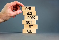 One size does not fit all symbol. Concept words One size does not fit all on wooden blocks. Businessman hand. Beautiful grey background. One size does not fit all business concept. Copy space.