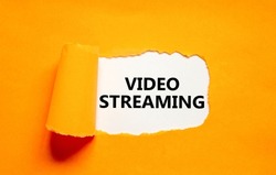 Video streaming symbol. Concept words Video streaming appearing behind torn orange paper. Beautiful orange background. Business, video streaming concept, copy space.