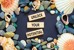 Unlock your potential symbol. Concept words Unlock your potential on wooden blocks. Sea stone, seashell. Beautiful black background. Business, psychological unlock your potential concept. Copy space.