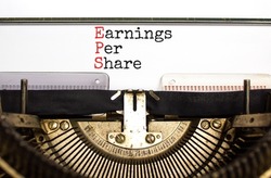 EPS earnings per share symbol. Concept words EPS earnings per share typed on old retro typewriter. Beautiful white background. Business and EPS earnings per share concept. Copy space.