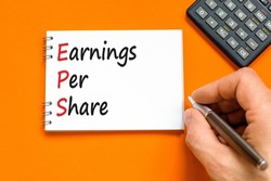 EPS earnings per share symbol. Concept words EPS earnings per share on white note on a beautiful orange background. Businessman hand. Business and EPS earnings per share concept. Copy space.